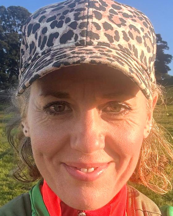 Siobhan, founder and personal trainer at ReBorn, smiling outdoors in a leopard-print cap